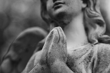 Obraz premium Praying angel statue symbolizing faith and eternal peace.