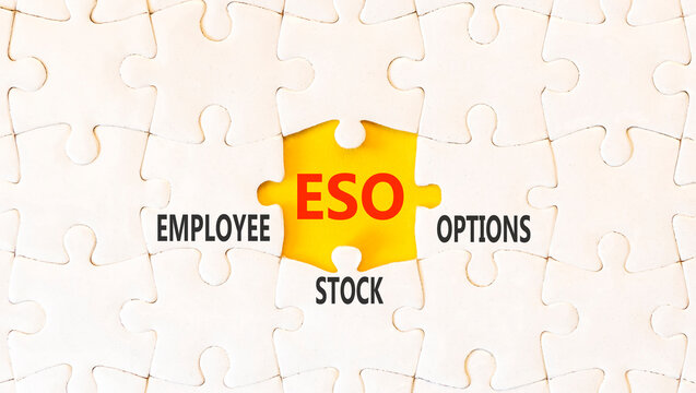 ESO employee stock options symbol. Concept words ESO employee stock options on beautiful white puzzles. Beautiful yellow background. Business ESO employee stock options concept. Copy space.