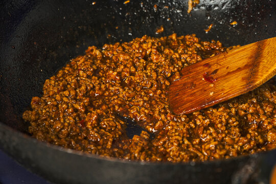 Minced meat cooking in wok with sauce for Soboro