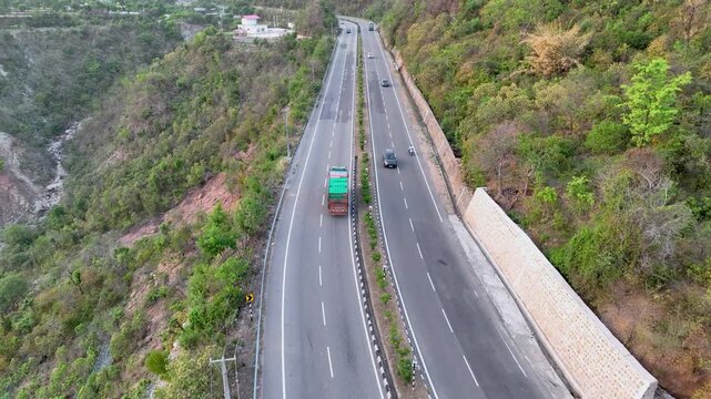Drone tracking Loaded commercial freight truck on scenic mountain road.  Truck driving on rugged national highway.