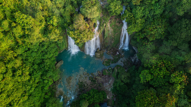 Aerial view of Cikaso Waterfall cascading into a turquoise pool surrounded by dense tropical forest in Sukabumi, West Java, Indonesia.