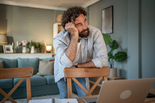 Man thinking about work procrastinating at home