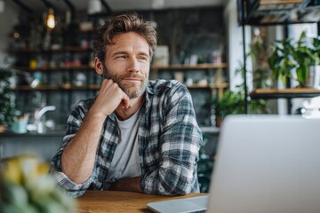 Fototapeta premium Professional man working in a bright home office space with modern decor, laptop, plants, and thoughtful expression capturing remote work lifestyle