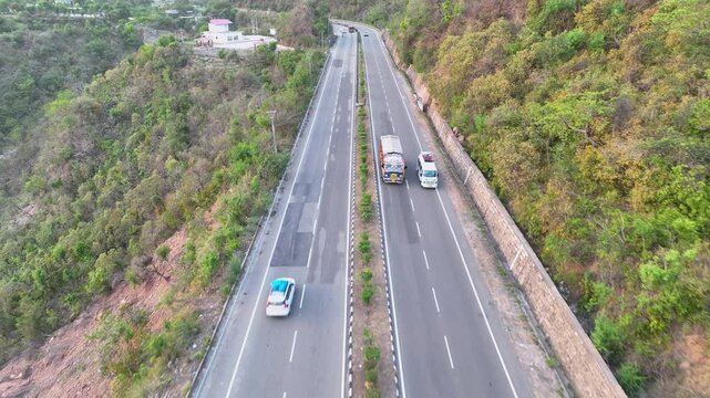 Drone tracking commercial freight truck on scenic mountain road.  Truck driving on rugged national highway.