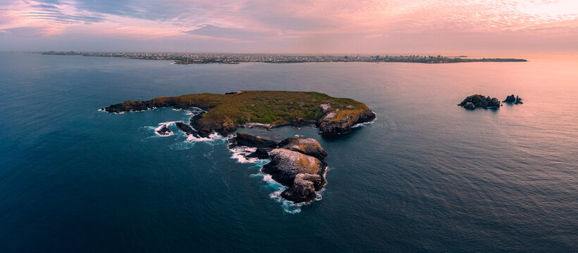 Aerial view of Ile de Madeleine surrounded by the Atlantic Ocean with the Dakar city skyline under a pink sunset sky Dakar, Dakar, Senegal.