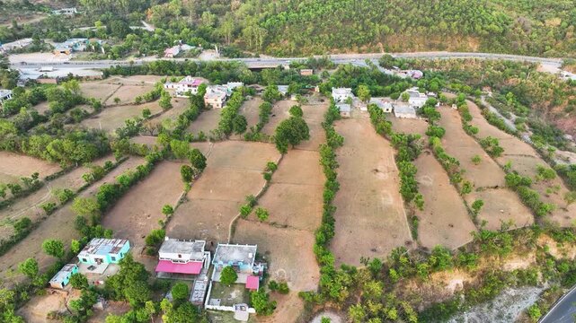 Cinematic sweeping shot of geometric terrace farming and stepped agricultural fields in rural India.