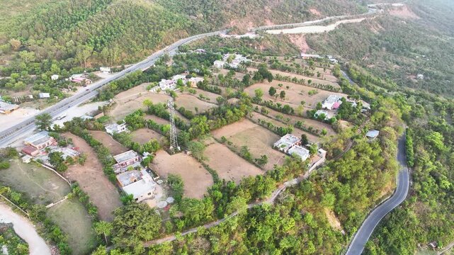 Cinematic aerial Orbit shot of geometric terrace farming and stepped agricultural fields in rural India.