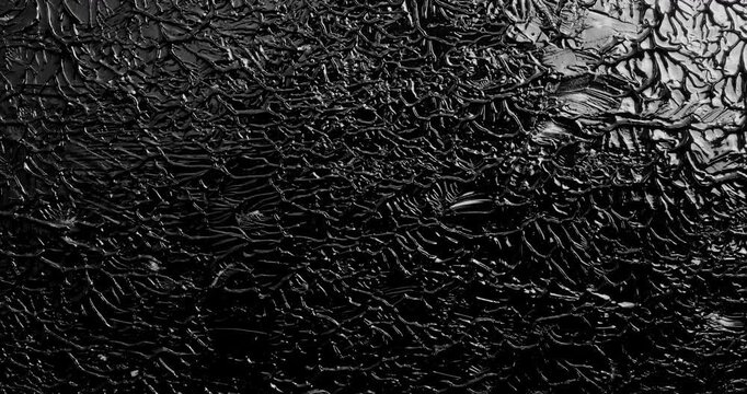 Black Paint Smear and Mix Stop Motion. Stop-motion sequence of thick glossy black paint being smeared, dragged and mixed across a dark surface.
