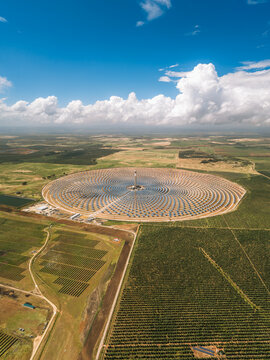Aerial view of the Torresol Energy Gemasolar concentrated solar power plant with concentric heliostat mirrors and a central tower in Fuentes de Andalucia, Andalucia, Spain.