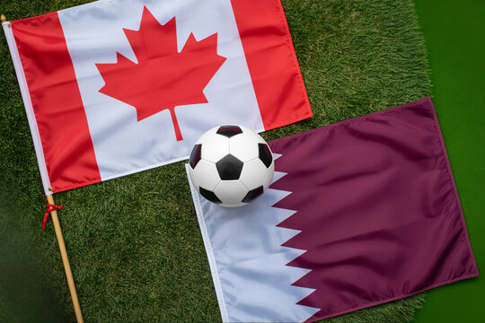 Canadian and Qatari flags with a soccer ball on artificial turf a vibrant sports themed composition canada qatar national football equipment green
