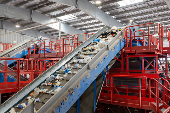 Waste conveyor belt with mixed garbage moving through recycling sorting line