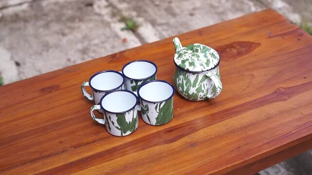 A traditional Indonesian green enamel blirik teapot. Made of iron coated with enamel. Featuring a distinctive classic green and white striped motif, it is often referred to as an old-fashioned teapot 