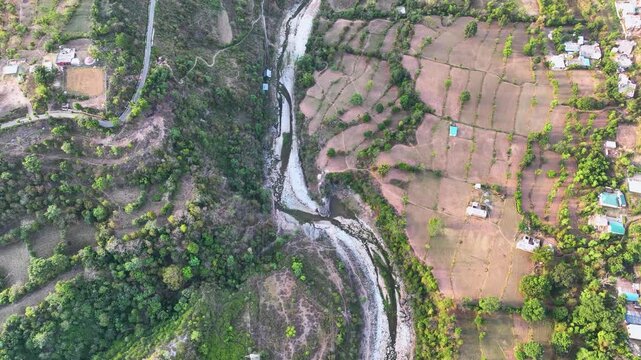 Bird's eye view of drought and dry riverbed next to farmland.