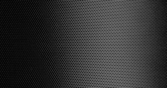 Black Perforated Metal Mesh. Smooth slow movement across extreme close-up of dark perforated metal grid with dramatic side lighting.	