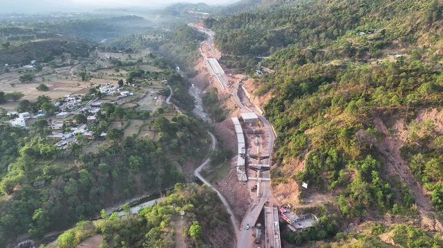 Infrastructure development: New highway cutting through mountains. Video focusing on regional progress, national connectivity, and transportation expansion in Rural India.