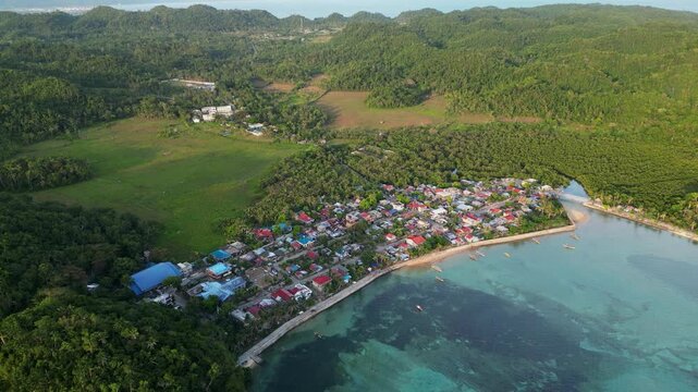 Picturesque aerial view of Magnesia Del Norte in Virac, Catanduanes, with a coastal fishing barangay, clear bay water, and lush hills - Philippines