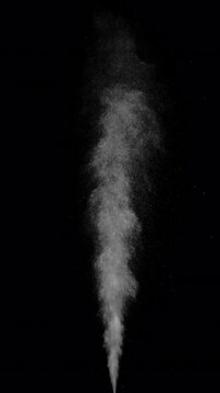 Hot Steam Plume Rising on Black. Vertical slow-motion of hot steam powerfully rising from below, forming a tall turbulent column that expands, gradually dissipates into fine sparkling particles.