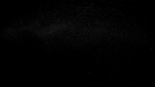 Hot Steam Plume Rising on Black. Slow-motion of hot steam powerfully rising from below, forming a tall turbulent column that expands, gradually dissipates into fine sparkling particles.