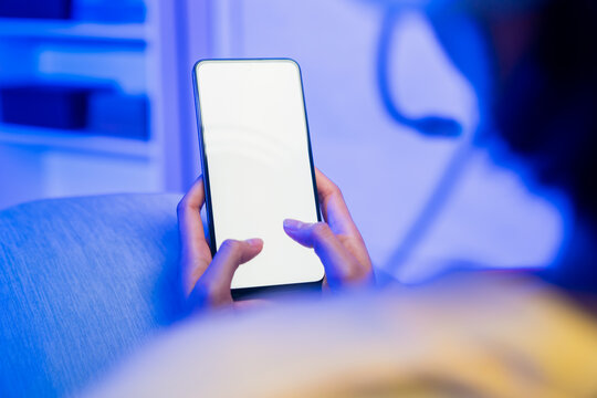 Hands holding smartphone with blank screen while playing mobile game, online gaming and digital entertainment concept.