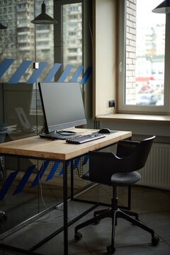 Vertical shot of student workspace featuring desktop computer on desk near window in modern study area
