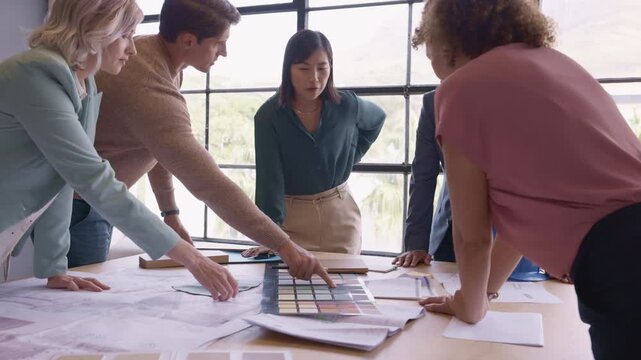Group of designers and interior architects reviewing plans