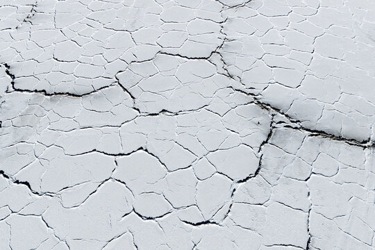 Aerial view of the intricate geometric cracked patterns on the white crust surface of the Uyuni Salt Flat in Potosi Department, Bolivia.