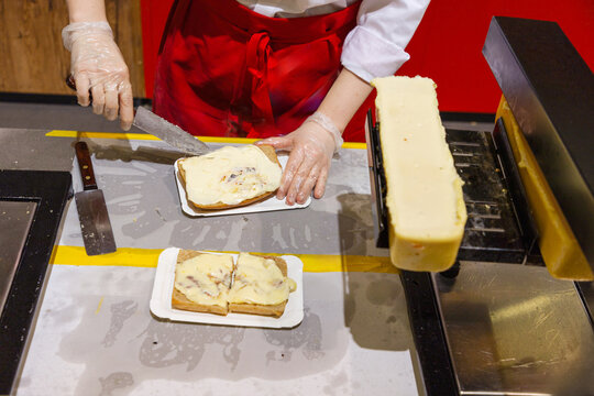 delicious wheel of raclette cheese has been heated on cutting edge.