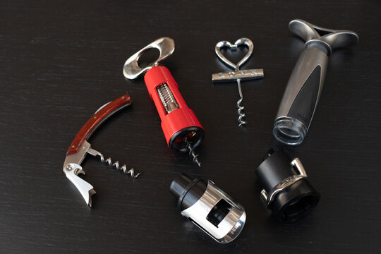 Sommelier kit includes waiter corkscrew and  vacuum stopper, sommelier tool selection displayed on elegant black background, sommelier accessory set makes perfect gift for wine enthusiast. 