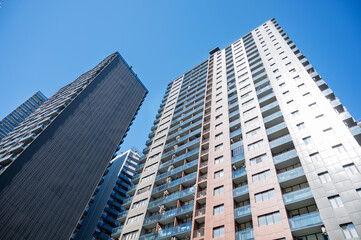 Fototapeta premium Modern high-rise residential buildings with new facades against a clear blue sky.