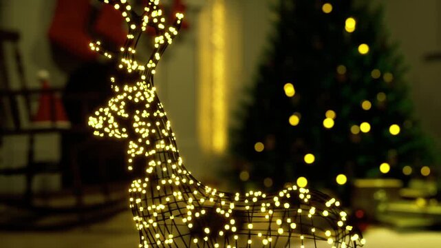Closeup of reindeer frame wrapped in micro lights showing intricate light pattern and sparkling points, blurred christmas tree backdrop and warm shimmer