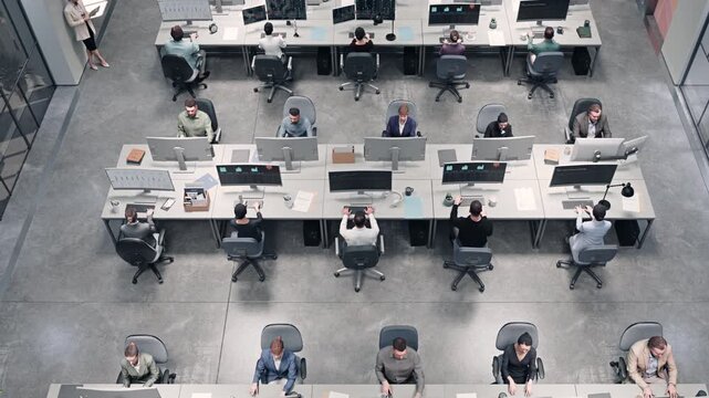 Overhead View of Diverse Adult Men and Women Typing at Computers in a Modern Open-plan Office, Working Across Long Desks With Monitors, Charts, Papers, Coffee, and a Colleague Standing Nearby.
