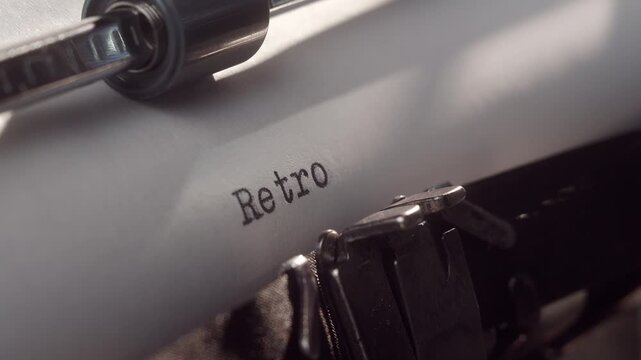Typewriter shows the word Retro on a sheet of paper in a close-up view during the day