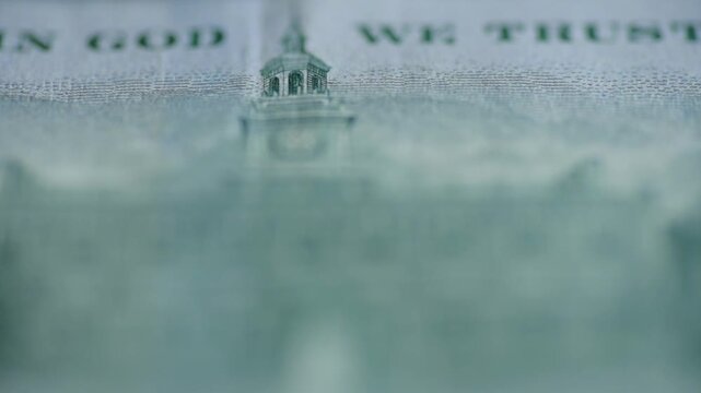 Closeup In God We Trust banknote detail, softfocus engraving of steeple, shallow depth, muted green palette, visible printing dots and paper texture, slow cinematic motion, mood