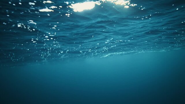 Calm Arctic underwater beneath rippled ocean surface in deep blue Norway water