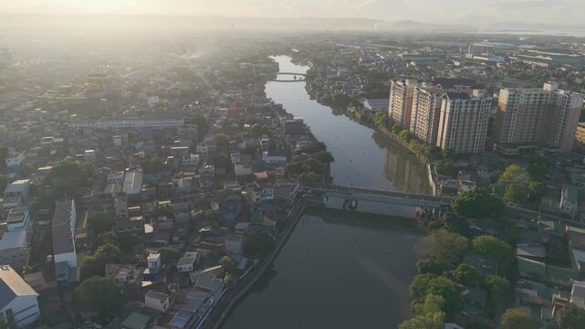 Drone footage moving forward above Pasig River with bridges, residential districts, and modern high-rise buildings in Metro Manila.