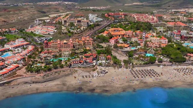 Aerial view of beachfront resort complex with sandy beach and turquoise water