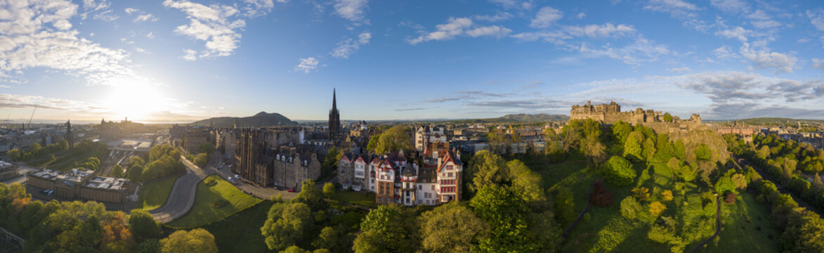 Aerial view of Edinburgh Castle and the historic city skyline with lush green parks under a bright golden hour sun Edinburgh, Scotland, United Kingdom.
