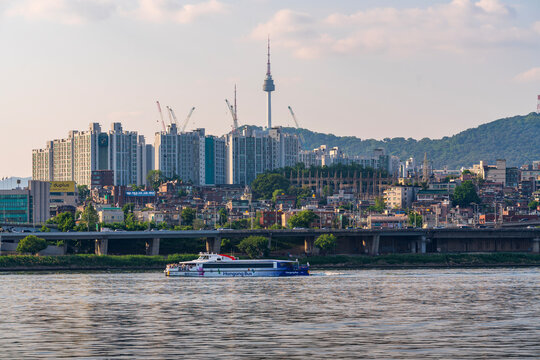 Seoul&rsquo;s skyline glows beside the Han River as the Hangang Bus cruises past Banpo Hangang Park, with the iconic Moonlight Rainbow Fountain adding charm to the city view.