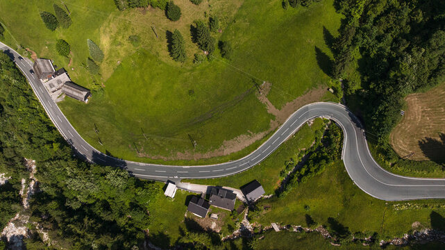 Spectacular drone overview reveals high mountain ridges along border of Austria and Slovenia. Massive Alpine peaks, deep valleys, and evergreen forests dominate majestic European landscape.