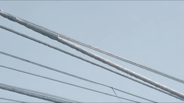 Steel cables and wire ropes creating a sturdy infrastructure, providing structural support and illustrating engineering complexity in modern construction against a clear blue sky