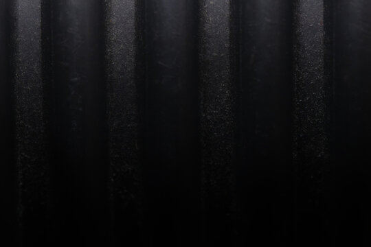 Macro shot of grey flexible corrugated PVC pipe surface. Abstract industrial background of plastic conduit or flexible hose with parallel vertical ribs for cable protection and construction concepts.