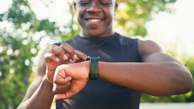 African American Man with Limb Difference Checks Smartwatch While Exercising Outdoors