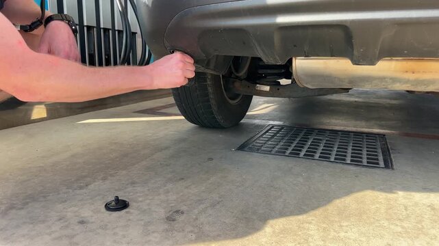 A man screws a metal adapter into a gas tank in a car. 4k