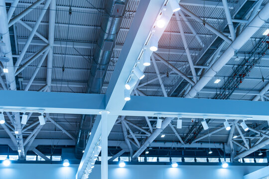 Directional LED lights on rails under the ceiling in a modern warehouse, shopping center building, office or other commercial real estate object.
