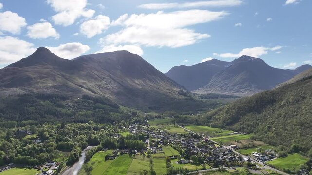 Sunny Spring Aerial Flight Over Glencoe Looking Towards Bidean Nam Bian with Mountains and Blue Sky
