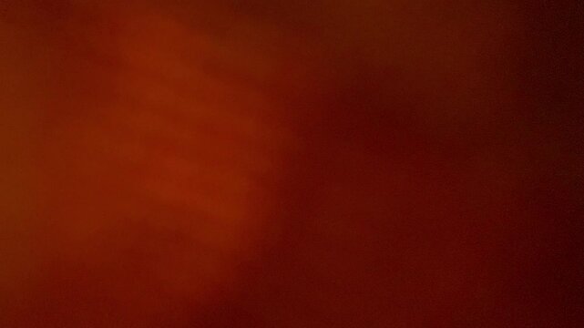 A man loads dirty laundry into the shiny drum of a washing machine, view from inside the washing machine