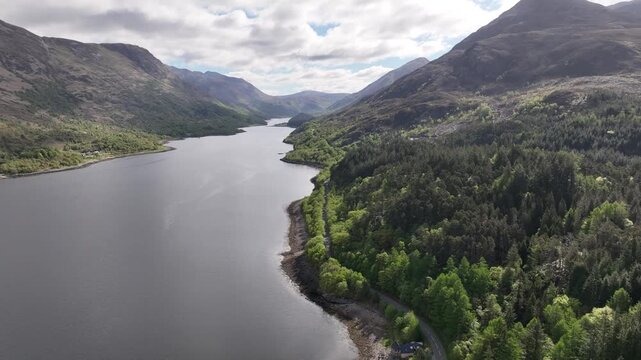 Left Orbit Above Loch Leven Looking Down the Valley with Road, Sun Reflection, Blue Sky and Mountains Ahead