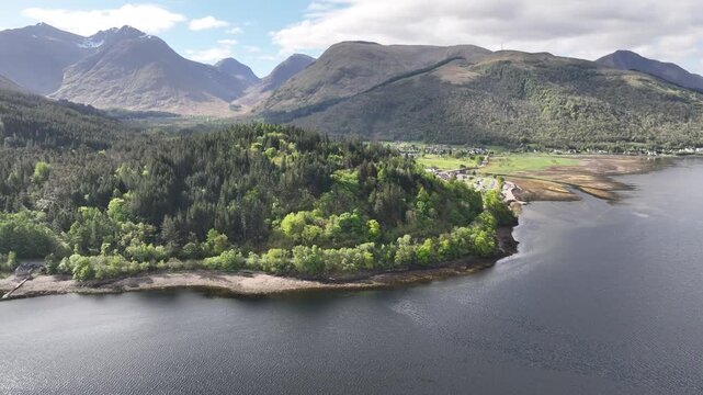 High Altitude Aerial Over Loch Leven with Glencoe Mountains, Snow‑topped Peaks, Green Forests and Sunlit Reflections