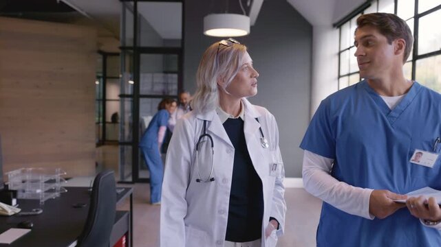 Mature doctor and mixed race nurse discussing patient case