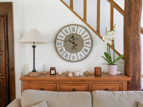 Int&eacute;rieur chaleureux avec horloge murale vintage et mobilier en bois dans une maison rustique